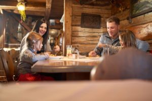 famile-beim-essen-in-uriger-hütte